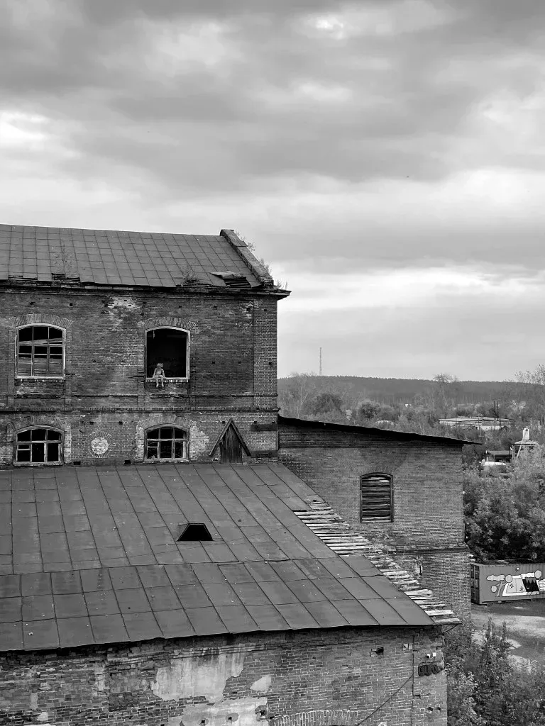 Плюшевый мишка в окне старого заводского корпуса